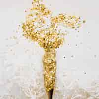 Bezpłatne zdjęcie skład nowego roku z złote konfetti w kieliszki do szampana