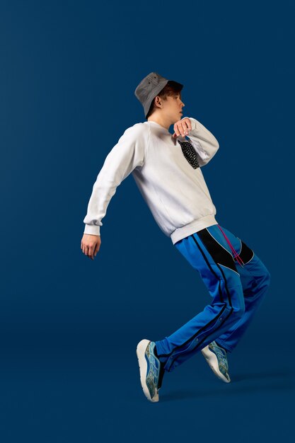 Skoki. Old-school fashioned młody człowiek taniec na białym tle na niebieskim studio