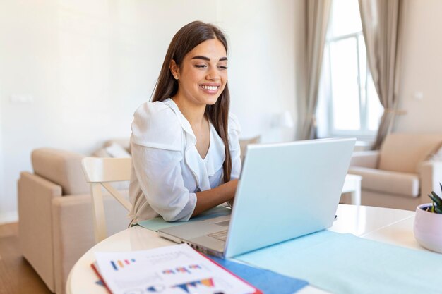 Skoncentrowana bizneswoman przedstawiająca wykresy i wykresy podczas rozmowy wideo online Młoda kobieta biznesu przeprowadzająca rozmowę konferencyjną z klientem na laptopie Zbliżenie biznesowa kobieta pracująca na laptopie w pomieszczeniu