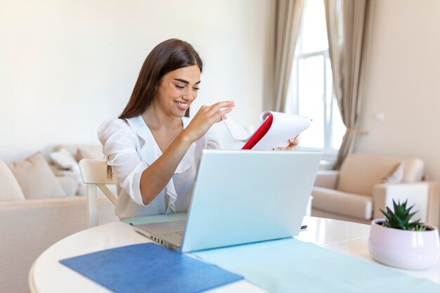 Skoncentrowana bizneswoman przedstawiająca wykresy i wykresy podczas rozmowy wideo online Młoda kobieta biznesu przeprowadzająca rozmowę konferencyjną z klientem na laptopie Zbliżenie biznesowa kobieta pracująca na laptopie w pomieszczeniu