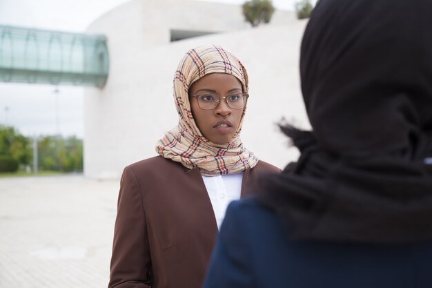 Bezpłatne zdjęcie skoncentrowana muzułmanka rozmawia z kolegą