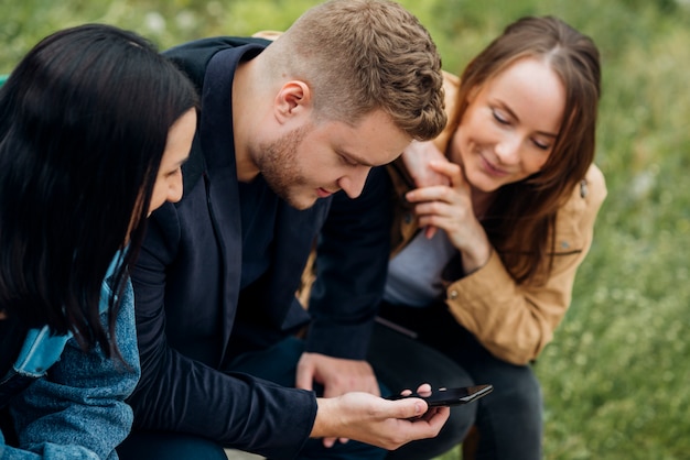 Skoncentrowani ludzie siedzą i korzystają z telefonu komórkowego