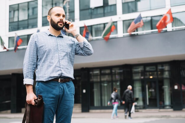 Skoncentrowany człowiek rozmawia przez telefon na świeżym powietrzu