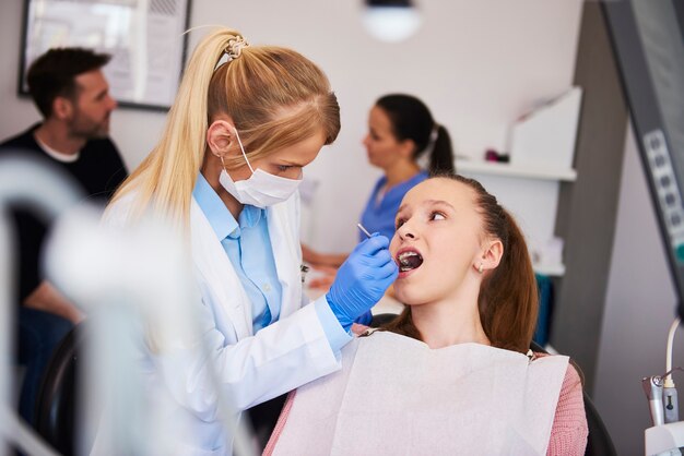 Skoncentrowany ortodonta używający lusterka dentystycznego