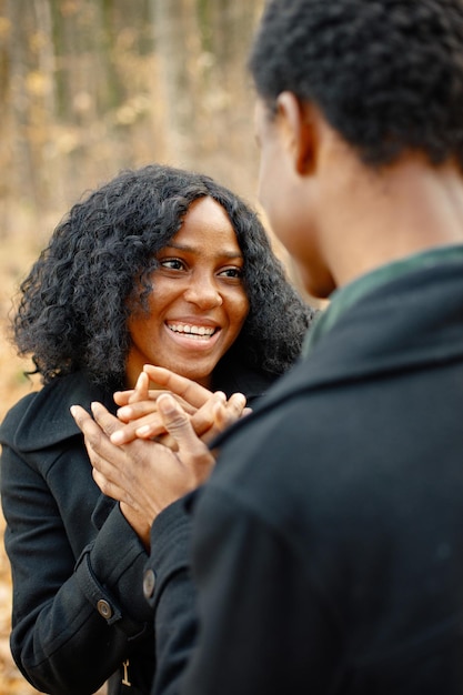 Skoncentruj się na twarzy czarnej kobiety. Czarny młody człowiek i jego dziewczyna trzymając się za ręce. Romantyczna para spacerująca w parku jesień na zachód słońca.