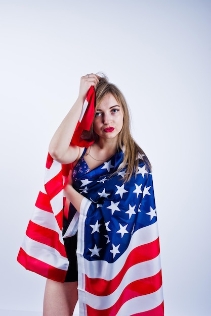 Śliczna dziewczyna w staniku i szortach z amerykańską flagą usa na białym tle