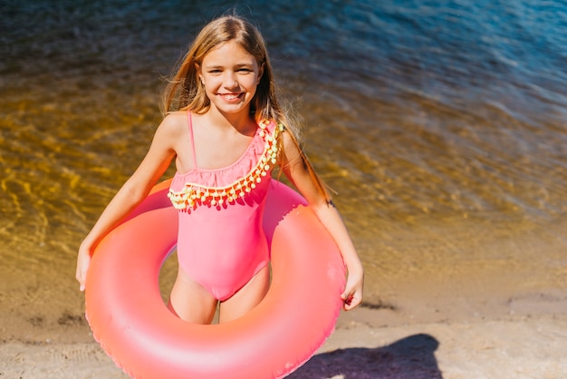 Śliczna dziewczyna z koloru pływania pierścionkiem na seashore