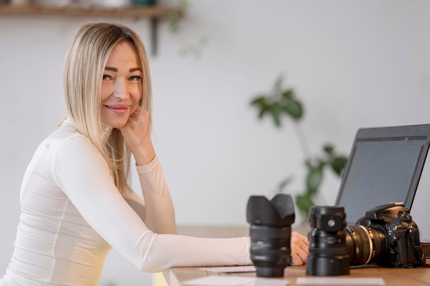 Śliczna kobieta przy jej workspace i kamera obiektywem