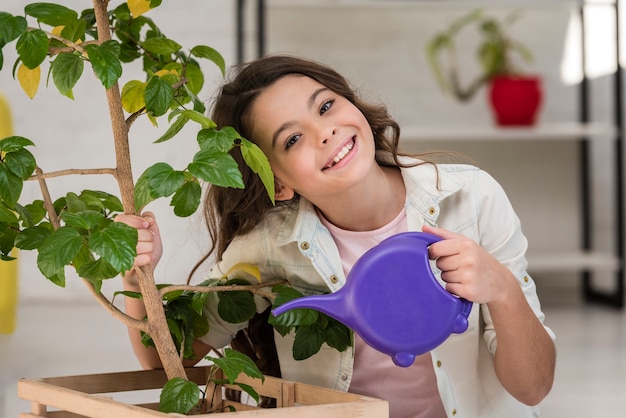 Śliczna mała dziewczynka nawadnia rośliny