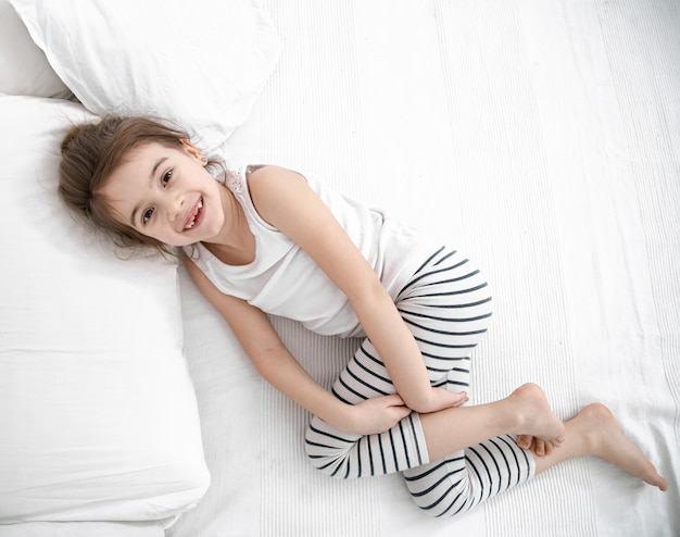 Bezpłatne zdjęcie Śliczna mała dziewczynka śpi w białym łóżku. koncepcja rozwoju dziecka i snu.