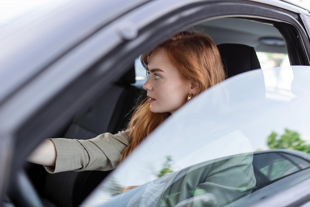Bezpłatne zdjęcie Śliczna młoda dama szczęśliwa prowadząca samochód obraz pięknej młodej kobiety prowadzącej samochód i uśmiechniętej portret szczęśliwej kobiety kierującej samochodem z pasem bezpieczeństwa
