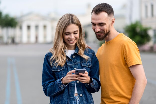 Śliczna młoda para za pomocą swojego telefonu komórkowego