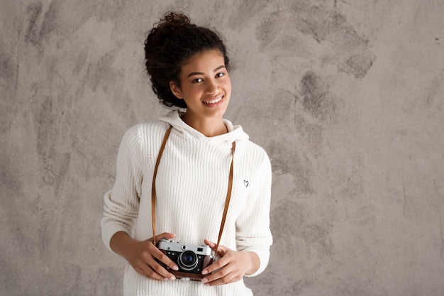 Śliczna modniś kobieta bierze fotografie na retro kamerze