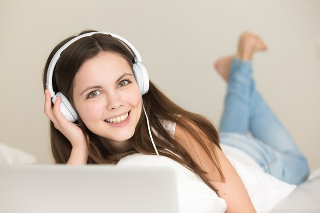 Śliczna nastoletnia dziewczyna cieszy się słuchającą nową muzykę online