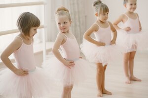 Śliczne małe balerinki w różowym stroju baletowym. w pokoju tańczą dzieci w pointach