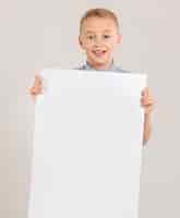 Bezpłatne zdjęcie Ślicznego chłopiec mienia pusty papier