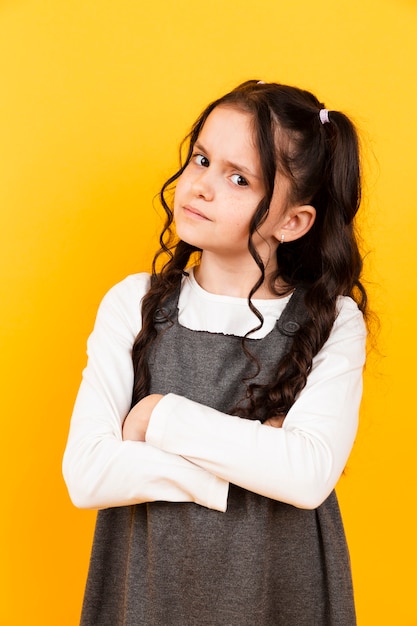 Śliczny mała dziewczynka portret pozuje na żółtym tle