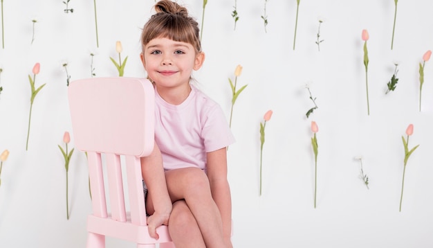 Bezpłatne zdjęcie Śliczny małej dziewczynki obsiadanie na krześle