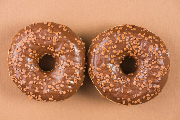 Słodcy donuts glazurujący z kropią na brown tle