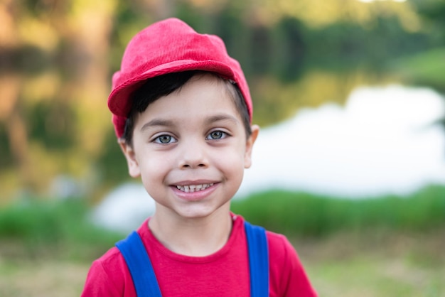 Bezpłatne zdjęcie słodki chłopak w niebiesko-czerwonym stroju w parku