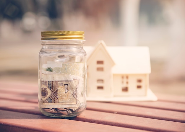 Bezpłatne zdjęcie słoik oszczędności z miniaturą domu
