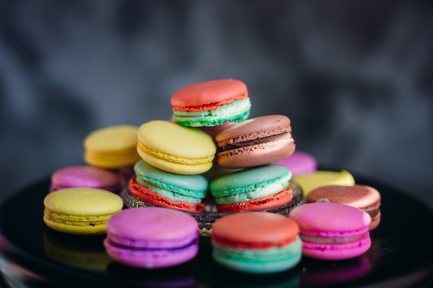 Słońce promienie kłamają nad kolorowymi macaroons na szklanym talerzu