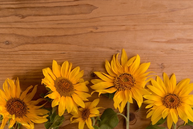 Słoneczniki na drewnianym rustykalnym stole jasnożółte letnie kwiaty z miejscem na kopię