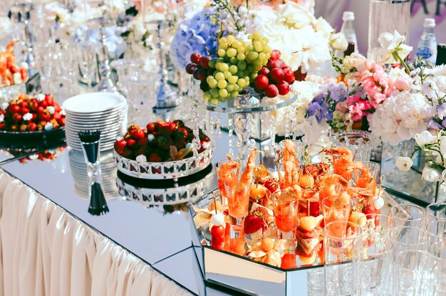 Ślubny catering z owocami i przekąskami na ozdobionym stole