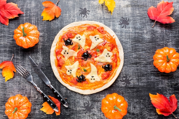 Smaczna pizza otoczona elementami Halloween