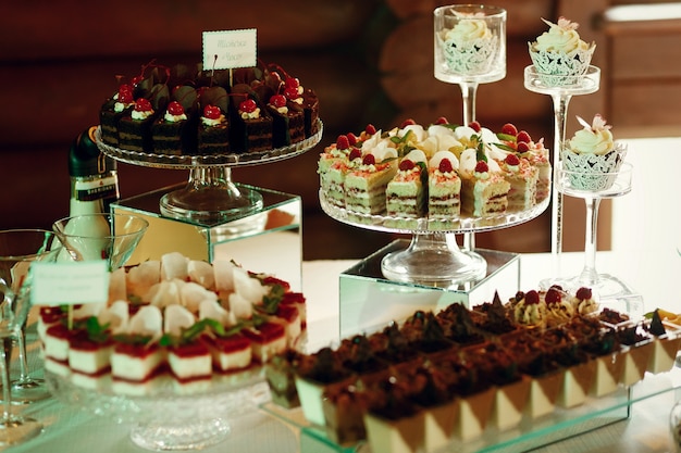 Smaczne owoce i czekoladowe ciasta stoją na szklanych talerzach