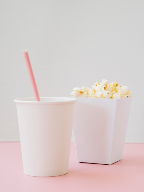 Bezpłatne zdjęcie smaczne pudełko popcornu z napojem na stole