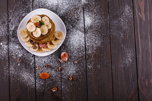 Smaczne śniadanie. Pyszne bułeczki z bananów, orzechów i mięty serwowane na białym talerzu