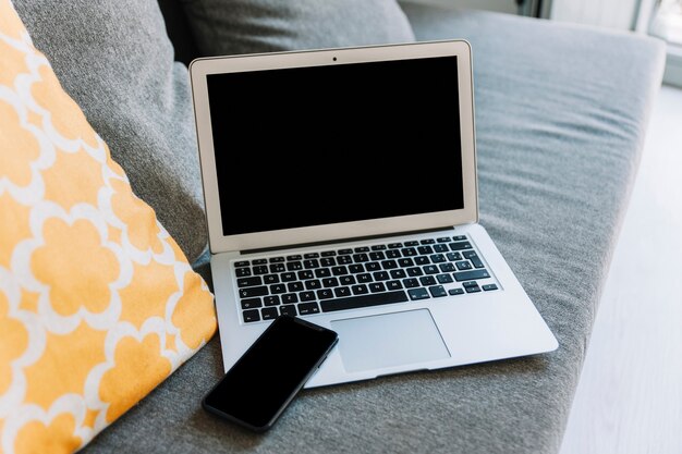 Smartphone i laptop na kanapie