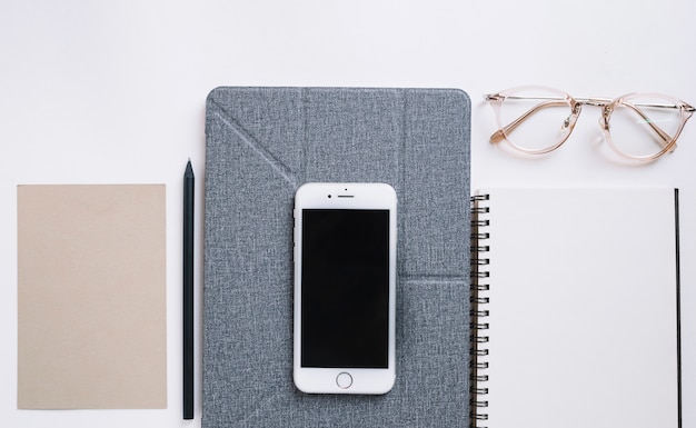 Bezpłatne zdjęcie smartphone między notebooka i papieru