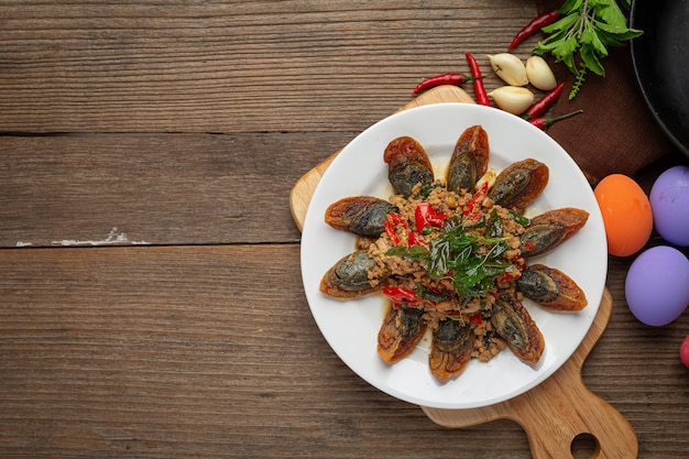 Smażona bazylia wymieszana z pikantnym jajkiem stulecia Podana z ryżem gotowanym na parze i sosem rybnym chili, tajskie jedzenie.