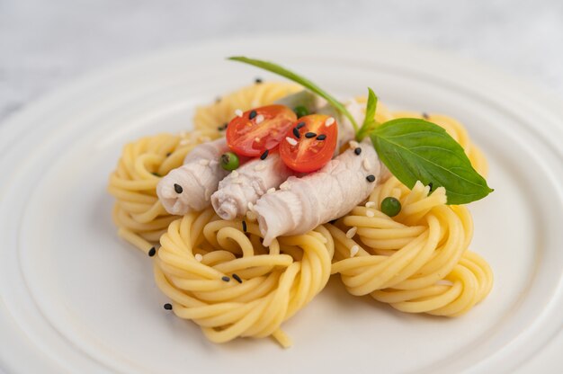 Smażone spaghetti i wieprzowina, pięknie ułożone w biały talerz.