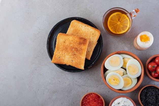Smażony chleb z filiżanką czarnej herbaty i gotowanymi jajkami.
