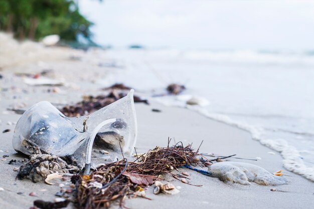 Śmieci na piasku plaży pokazuje problem zanieczyszczenia środowiska