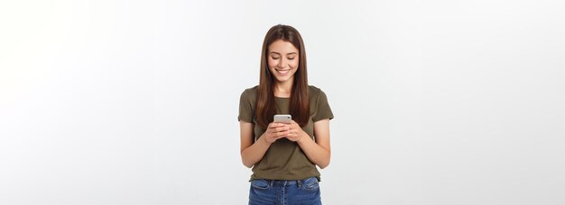 Śmiejąca się kobieta rozmawiająca i wysyłająca SMS-y przez telefon na białym tle