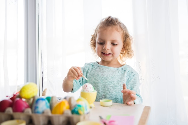 Bezpłatne zdjęcie Śmieszna dziewczyna maluje jajko