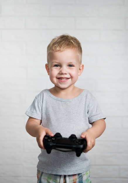 Smiley boy patrząc na kamery z joystickiem