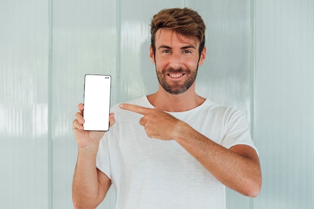 Smiley brodaty mężczyzna pokazuje telefon komórkowego