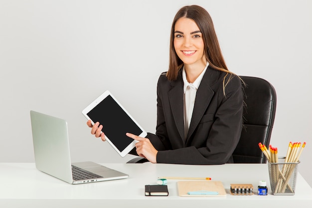 Bezpłatne zdjęcie smiley businesswoman pracy z tabletem