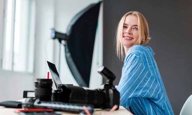 Smiley fotograf kobieta siedzi przy biurku