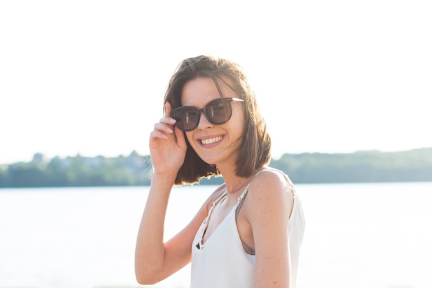 Smiley kobieta jest ubranym okulary przeciwsłonecznych