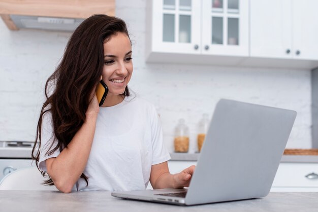 Smiley kobieta patrzeje na jej laptopie