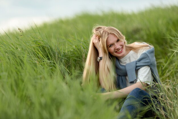 Smiley kobieta pozuje przez trawy
