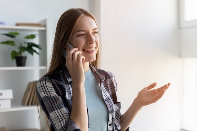 Smiley kobieta rozmawia przez telefon w pomieszczeniu