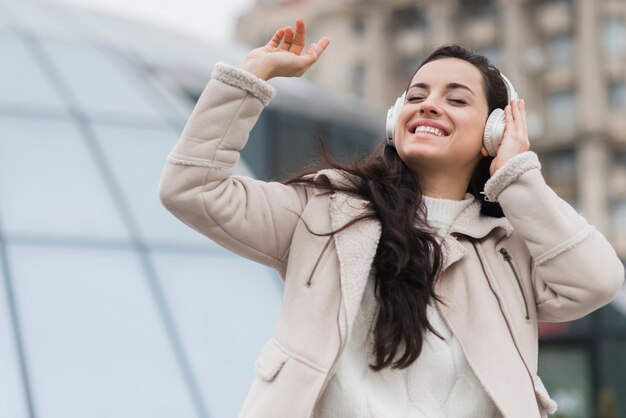 Smiley kobieta słucha muzyka na hełmofonach