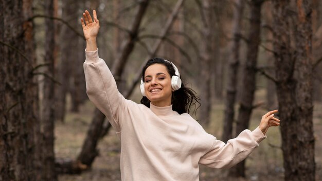 Smiley kobieta słuchania muzyki w słuchawkach